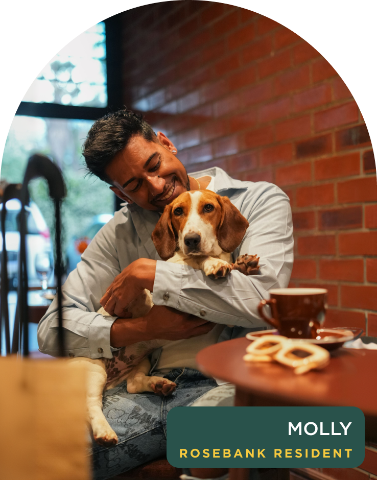 Guest cuddling Molly, a resident rescue dog at Home Suite Hotels Rosebank