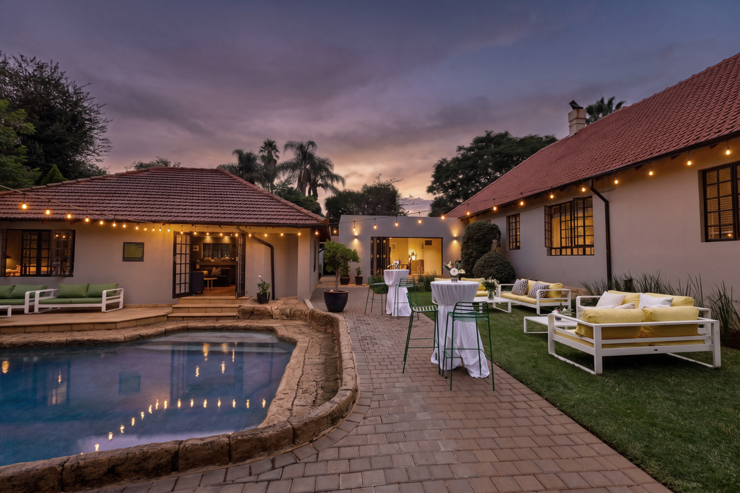Garden event space with pool at dusk at Home Suite Hotels Rosebank