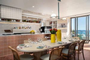 Communal kitchen and dining area at Home Suite Hotels Sea Point, with a set table and ocean views