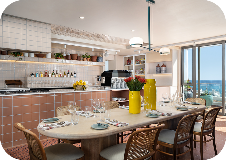 Communal kitchen and dining area at Home Suite Hotels Sea Point, with a set table and ocean views