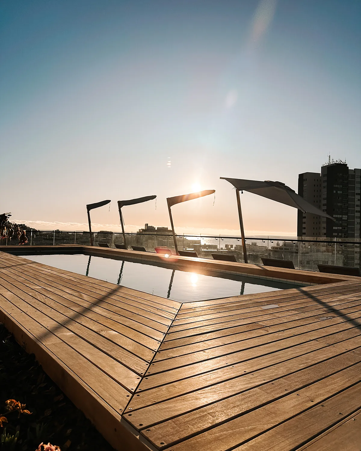 Rooftop pool deck at sunset at Home Suite Hotels Station House, Sea Point